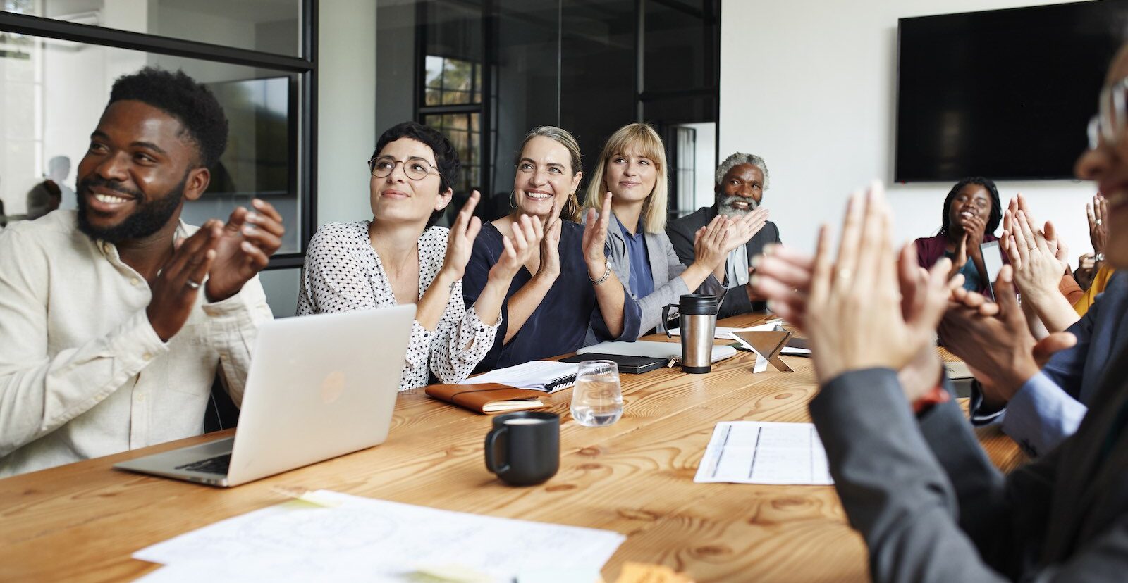 Geschäftsleute applaudieren bei einem Meeting im Büro