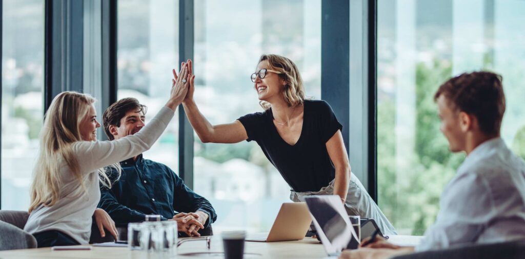 Weibliche Unternehmerin feiert Erfolg mit Franchisepartnern.