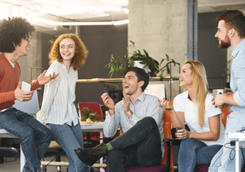 Eine Gruppe junger Menschen führt ein unterhaltsames Gespräch im Büro