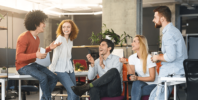 Eine Gruppe junger Menschen führt ein unterhaltsames Gespräch im Büro