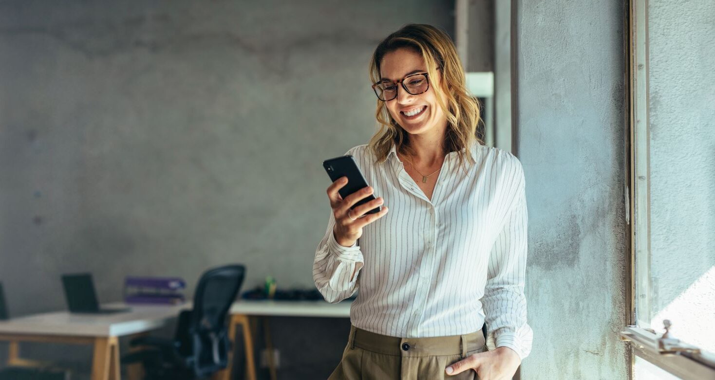 Selbstständige Unternehmerin mit Handy in der Hand