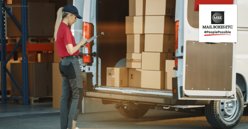 Mujer repartidora revisando furgoneta con cajas