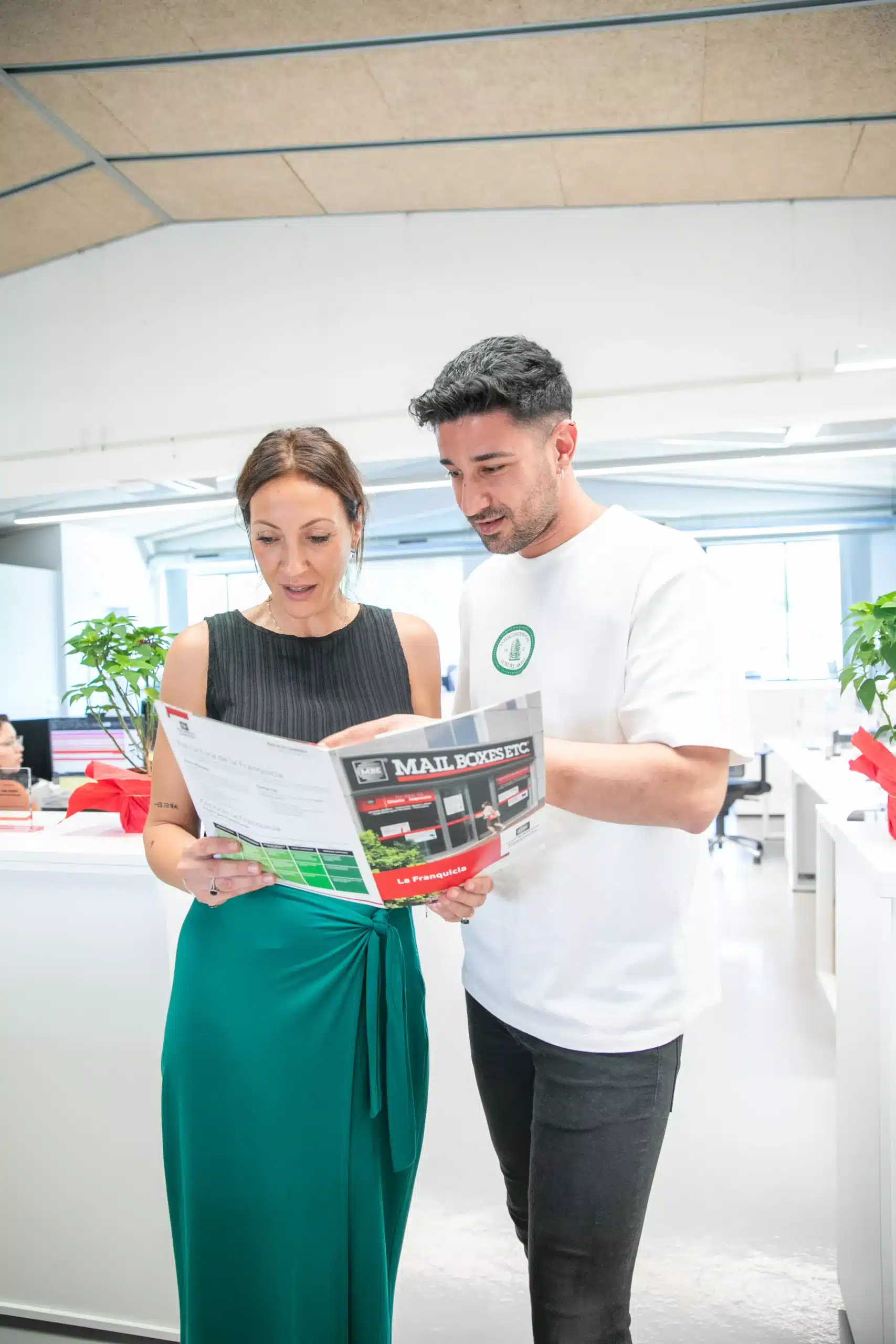 Mujer y hombre leyendo catalogo de MBE en una oficina