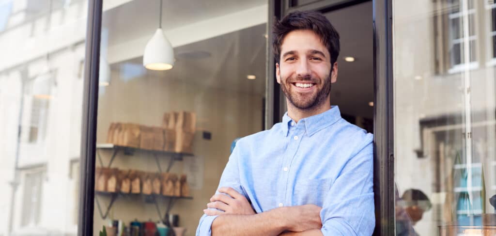Emprendedor sonriente frente a un nuevo centro franquiciado, listo para abrir su negocio en España en 2025