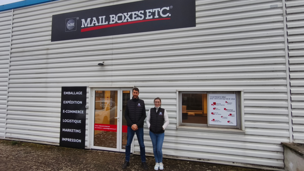 Photo du Centre Mail Boxes Etc. de Villeneuve Saint Germain près de Soissons, avec le franchisé Aymeric Leveau et sa salariée.