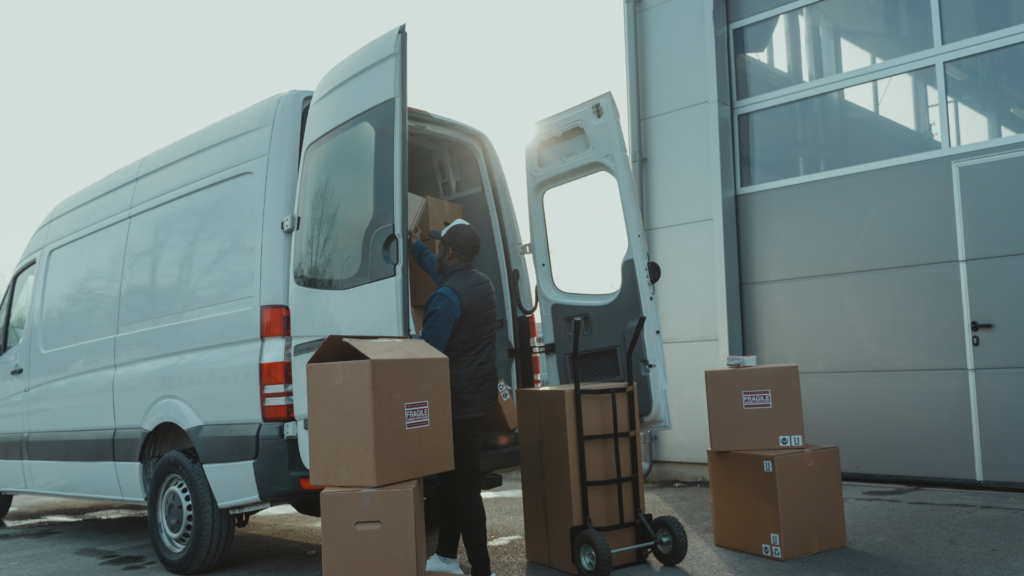 Photo d'un livreur de colis à l'arrière de son camion.